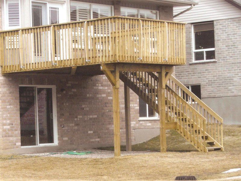 A brick house with a wooden deck and stairs