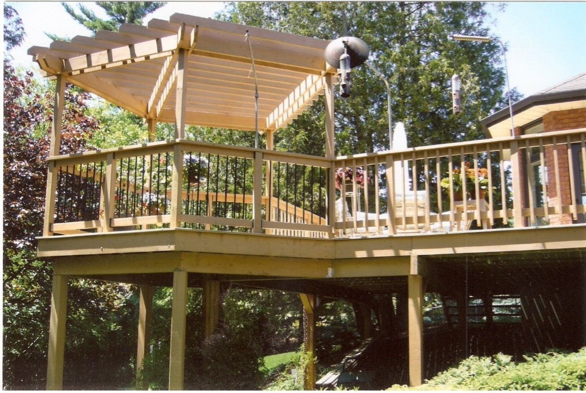 A wooden deck with a pergola on top of it