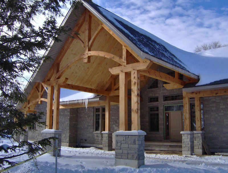 A house with a wooden porch and a snowy roof
