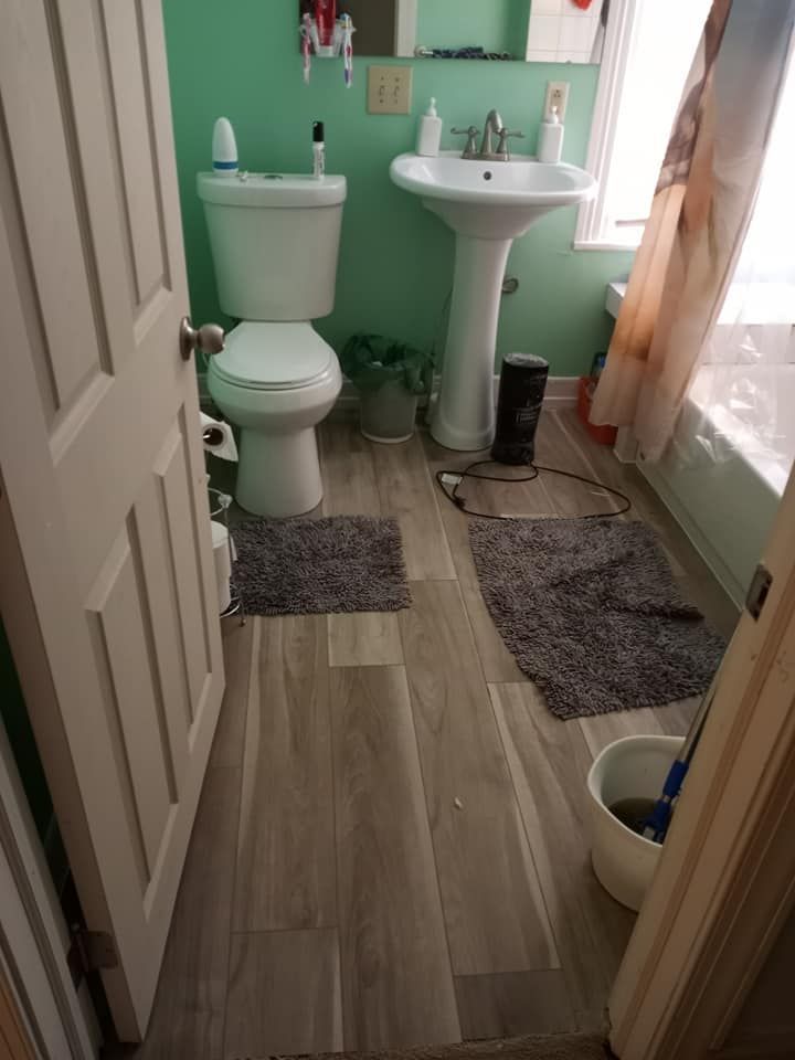 A bathroom with a toilet , sink , and bathtub.