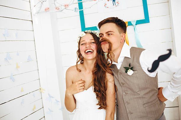 Bride and groom posing with silly mustache props