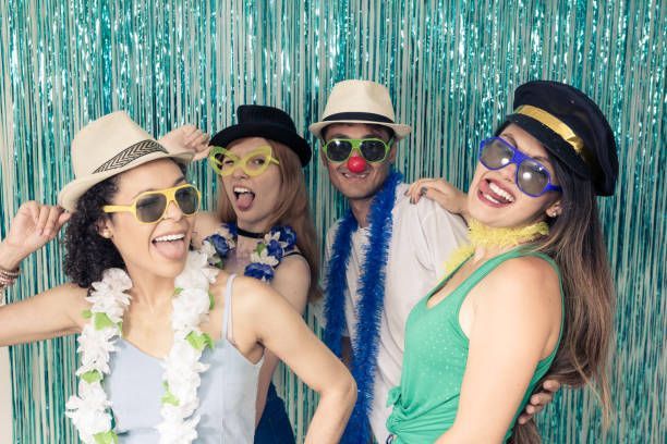 Friends posing with funny props in a photo booth