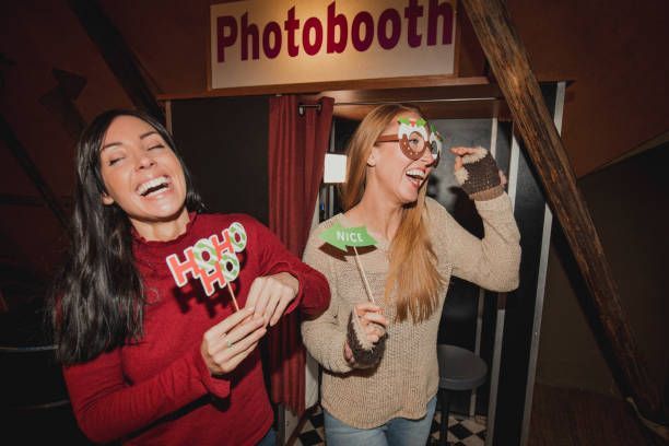 Two women laughing by a photobooth
