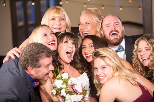 Smiling wedding guests posing with the bride
