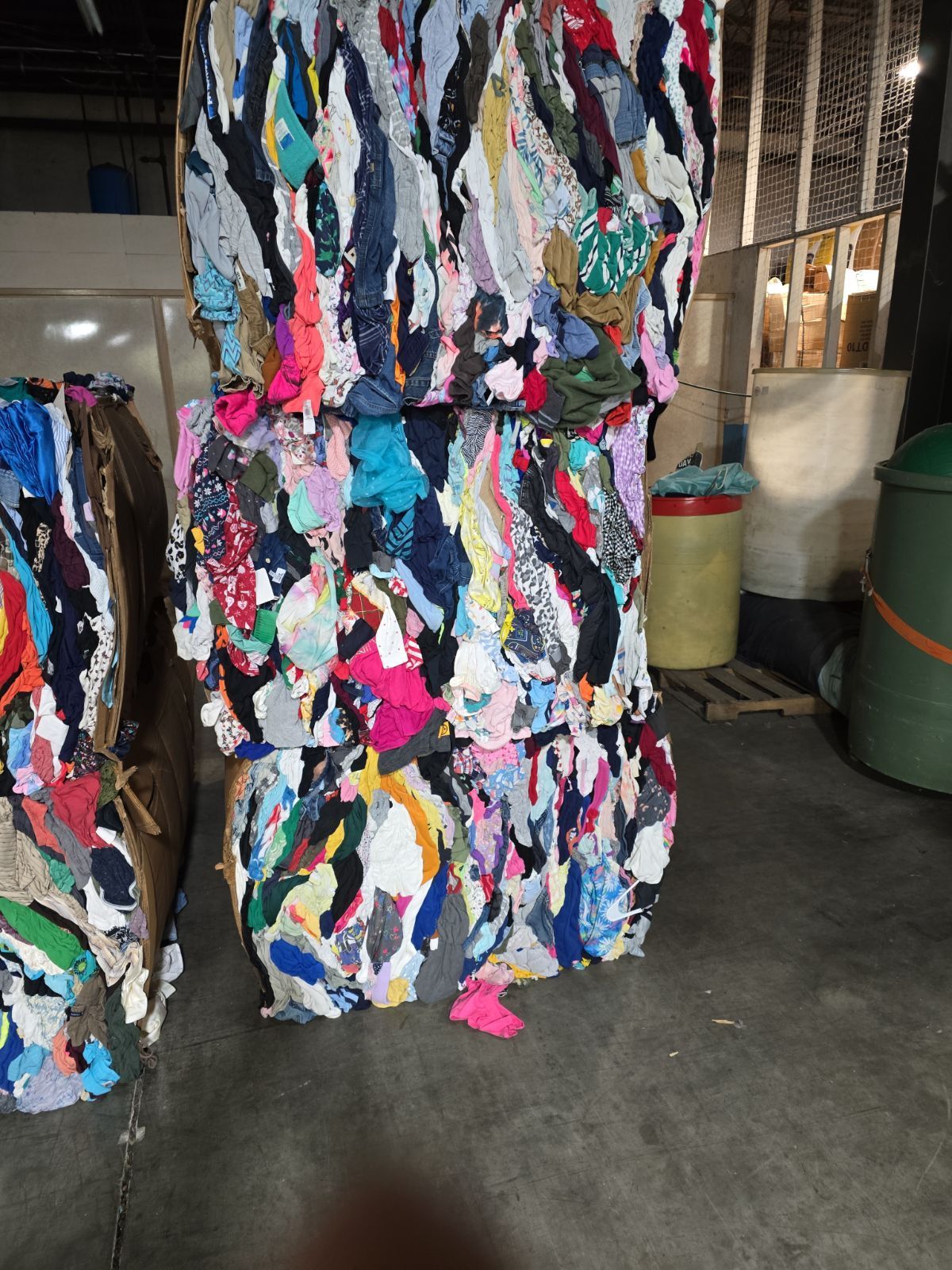 A pile of clothes is stacked on top of each other in a warehouse.