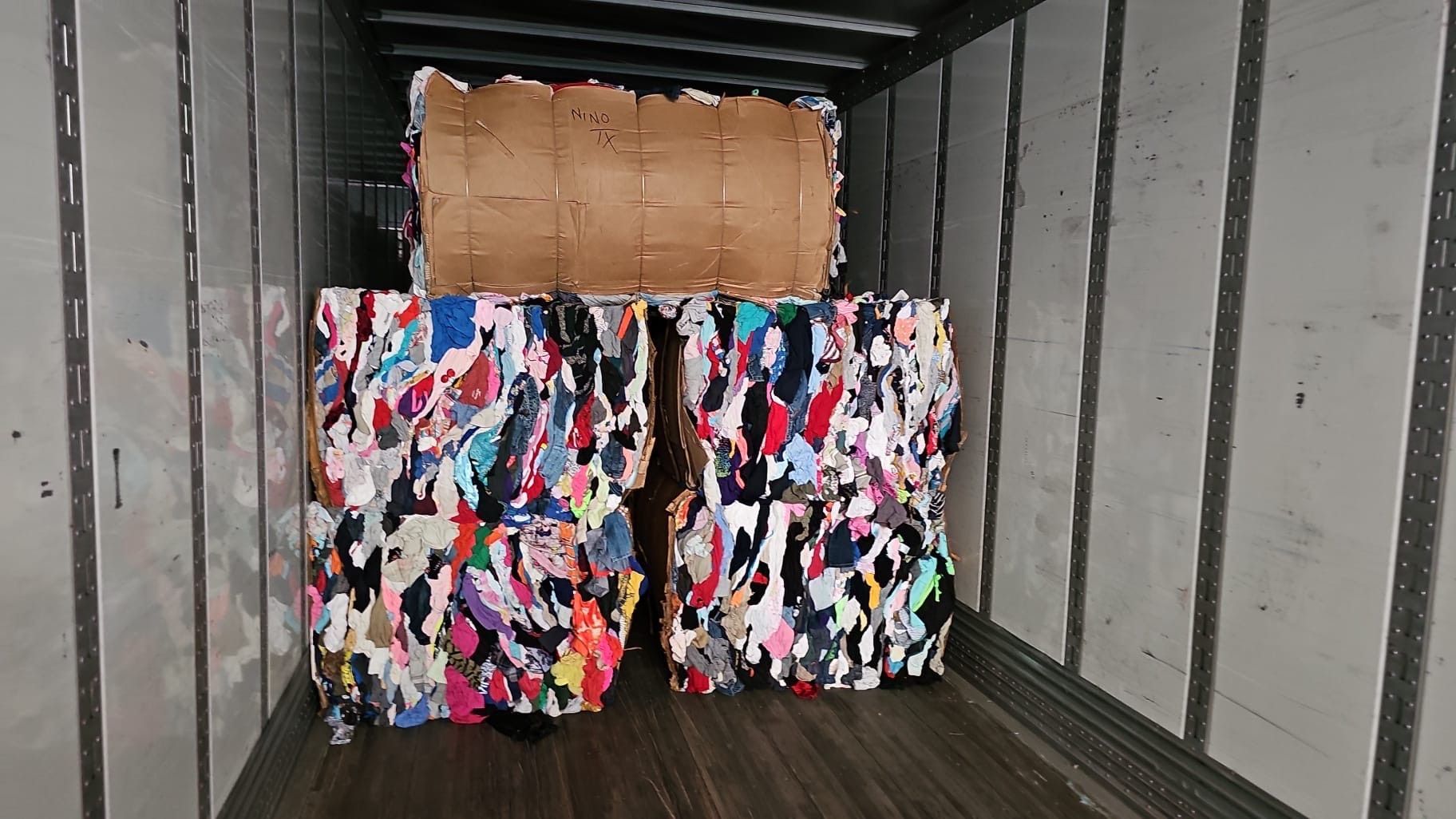 A truck filled with lots of clothes and a cardboard box.