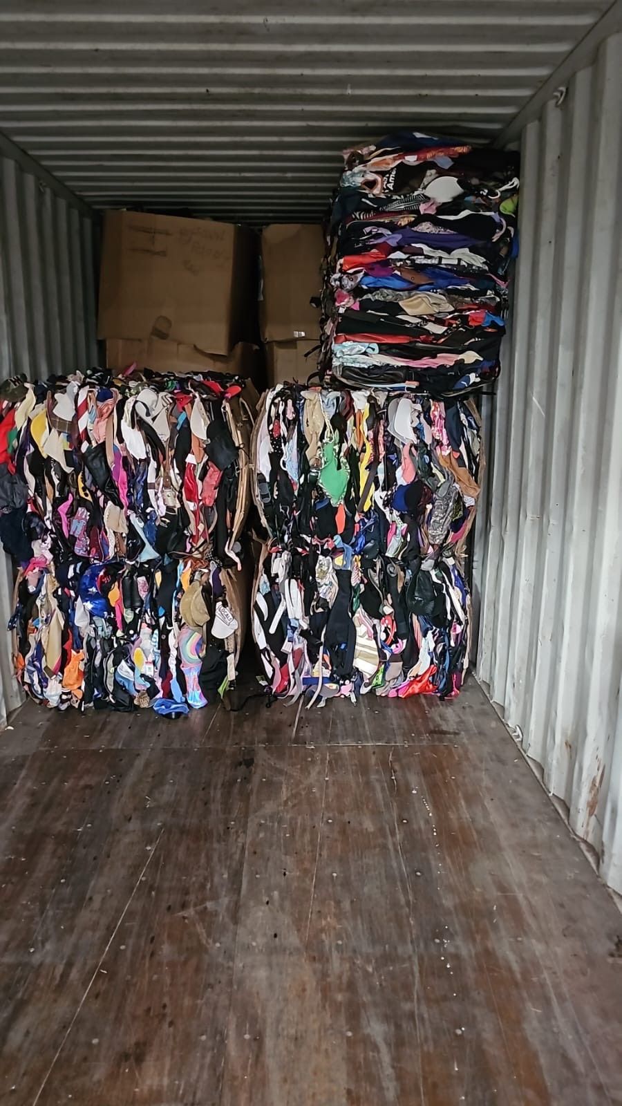 A container filled with lots of clothes and boxes.