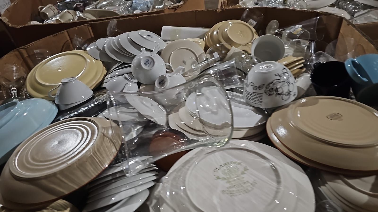 A pile of plates , bowls , cups and glasses