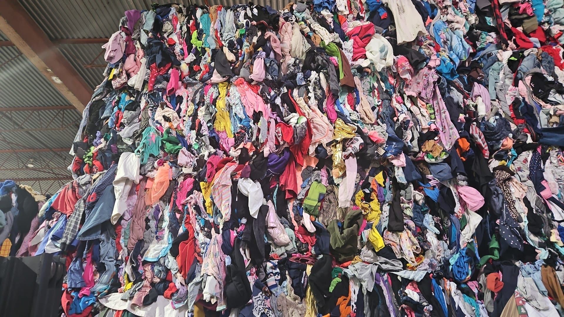 A large pile of colorful clothes is sitting on top of each other.