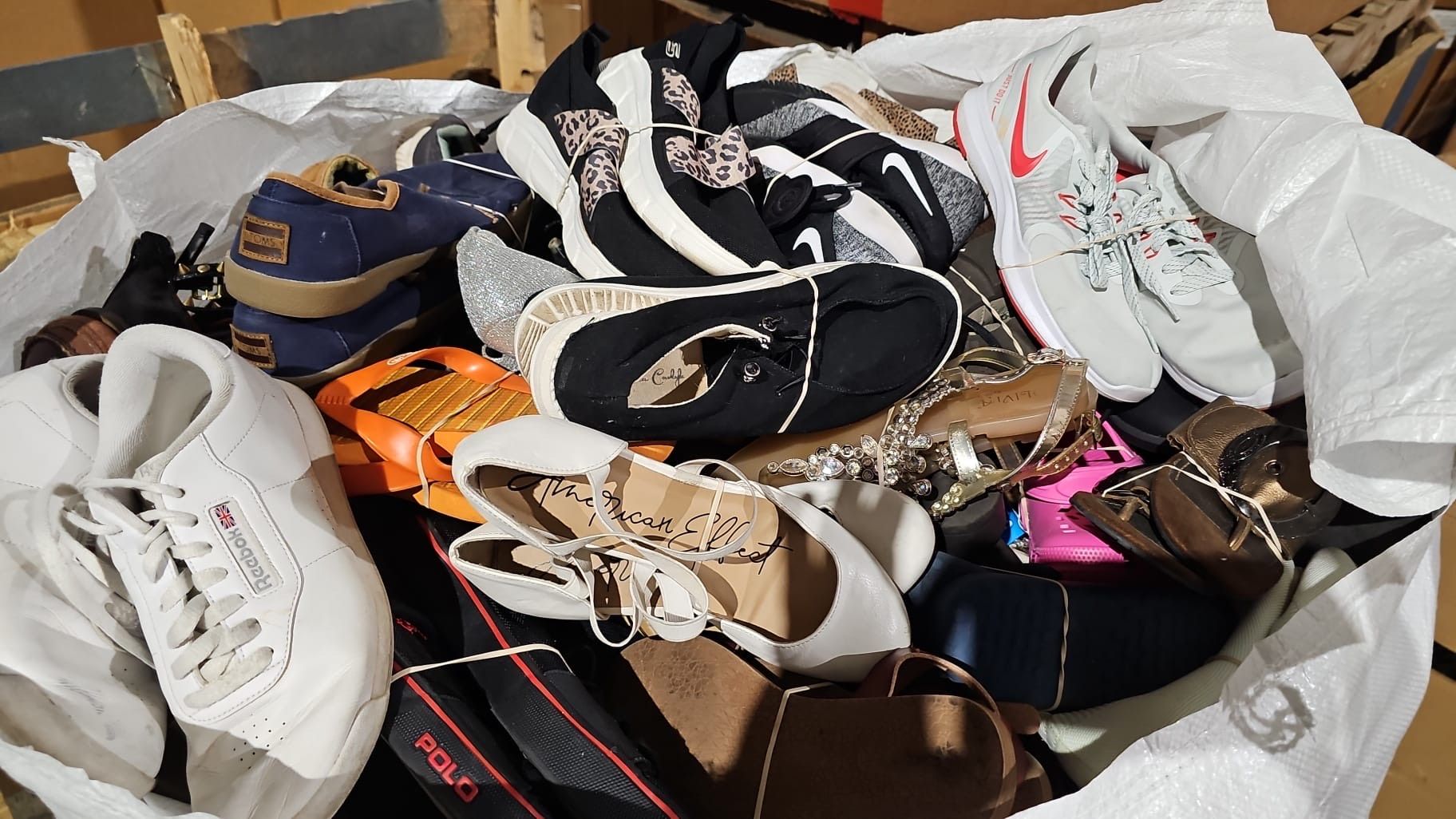 A bag filled with a variety of shoes and sandals