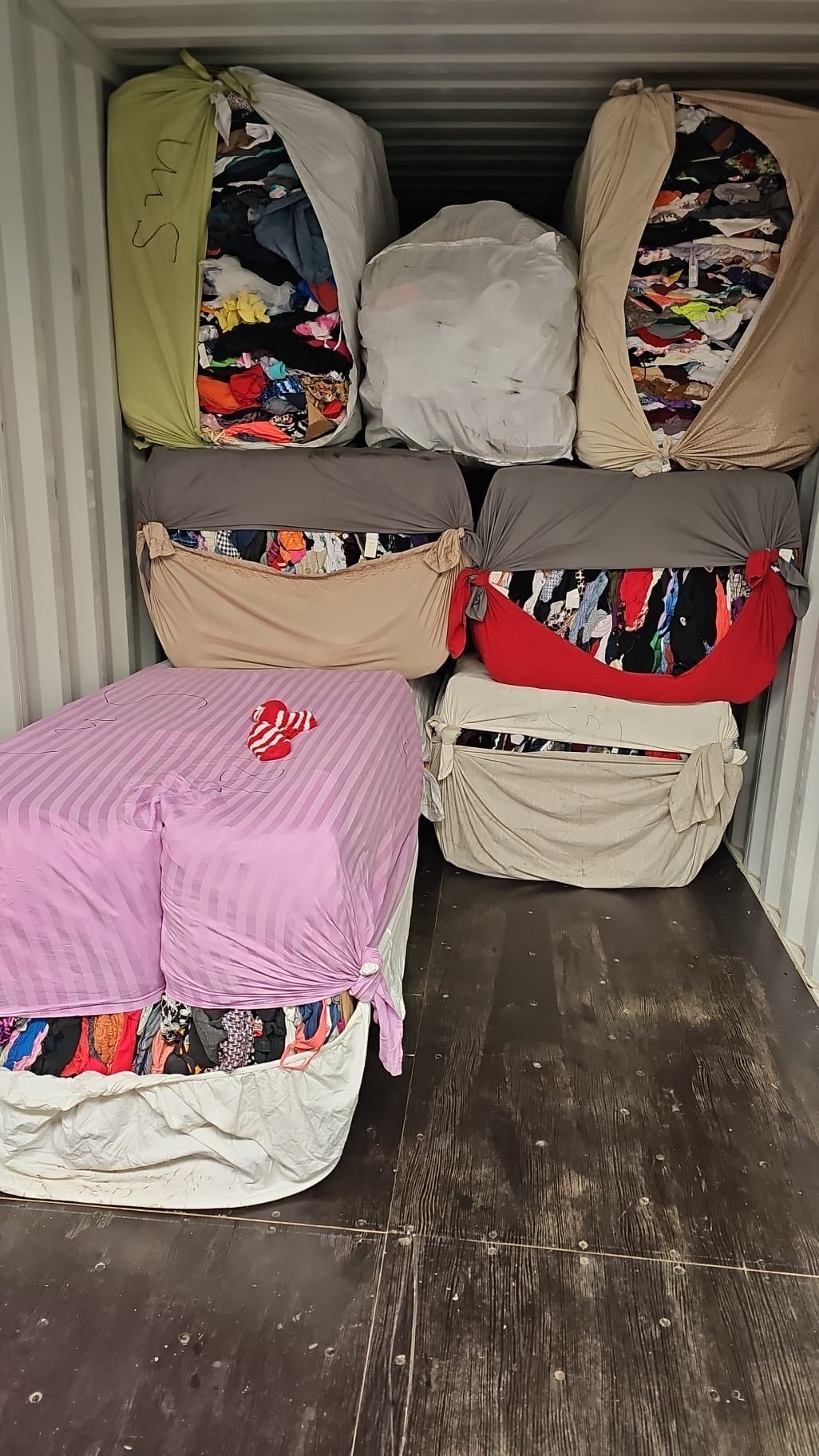 A container filled with lots of blankets and pillows.