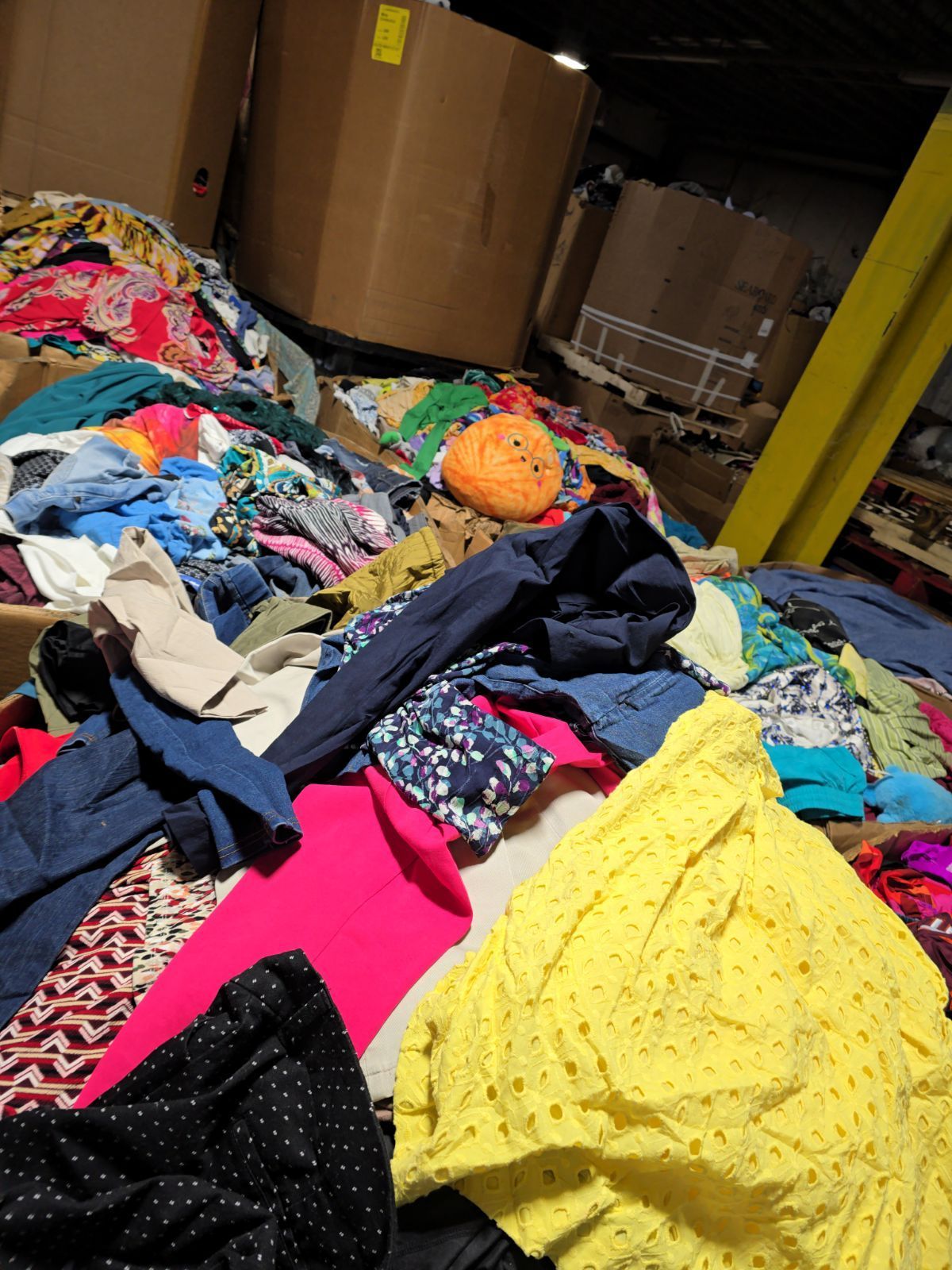 A pile of clothes is sitting on top of a table in a warehouse.