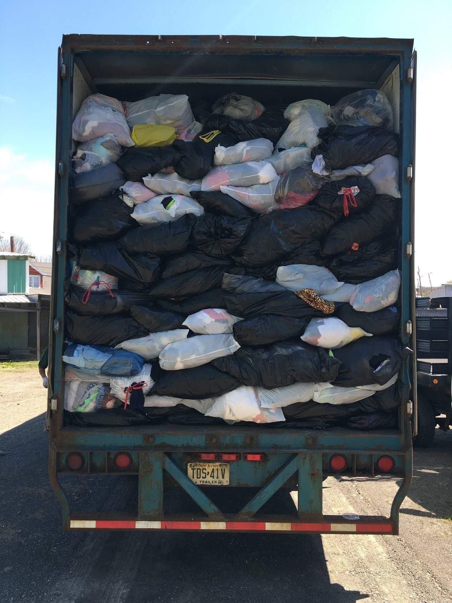 A truck with a new york license plate is full of bags