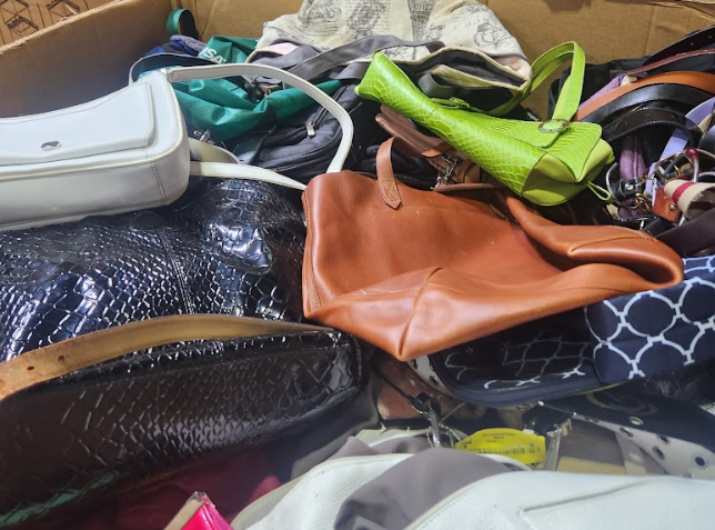 A pile of handbags including a green one