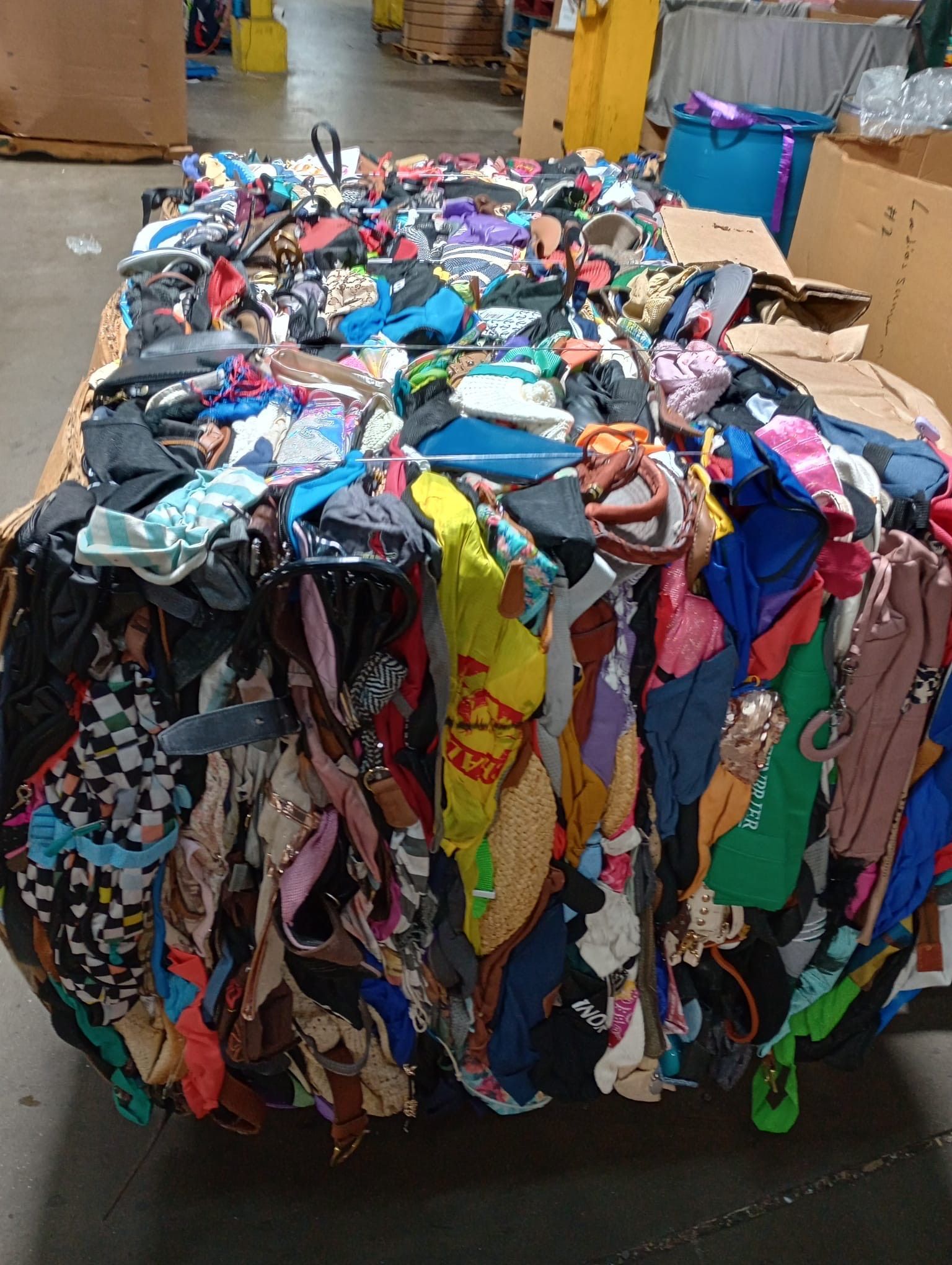 A pile of clothes is sitting on top of a cardboard box.