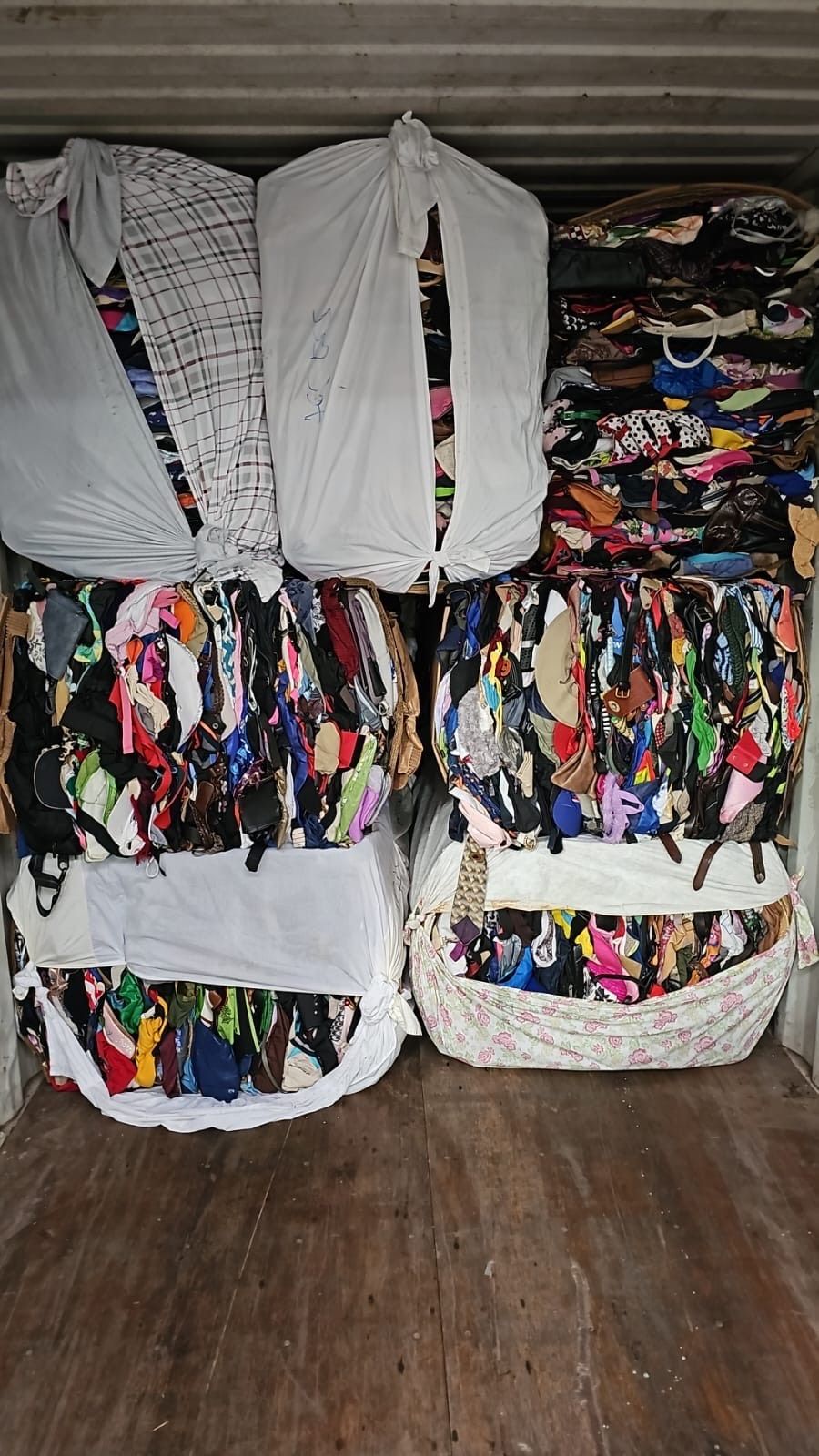 A bunch of clothes are stacked on top of each other in a container.