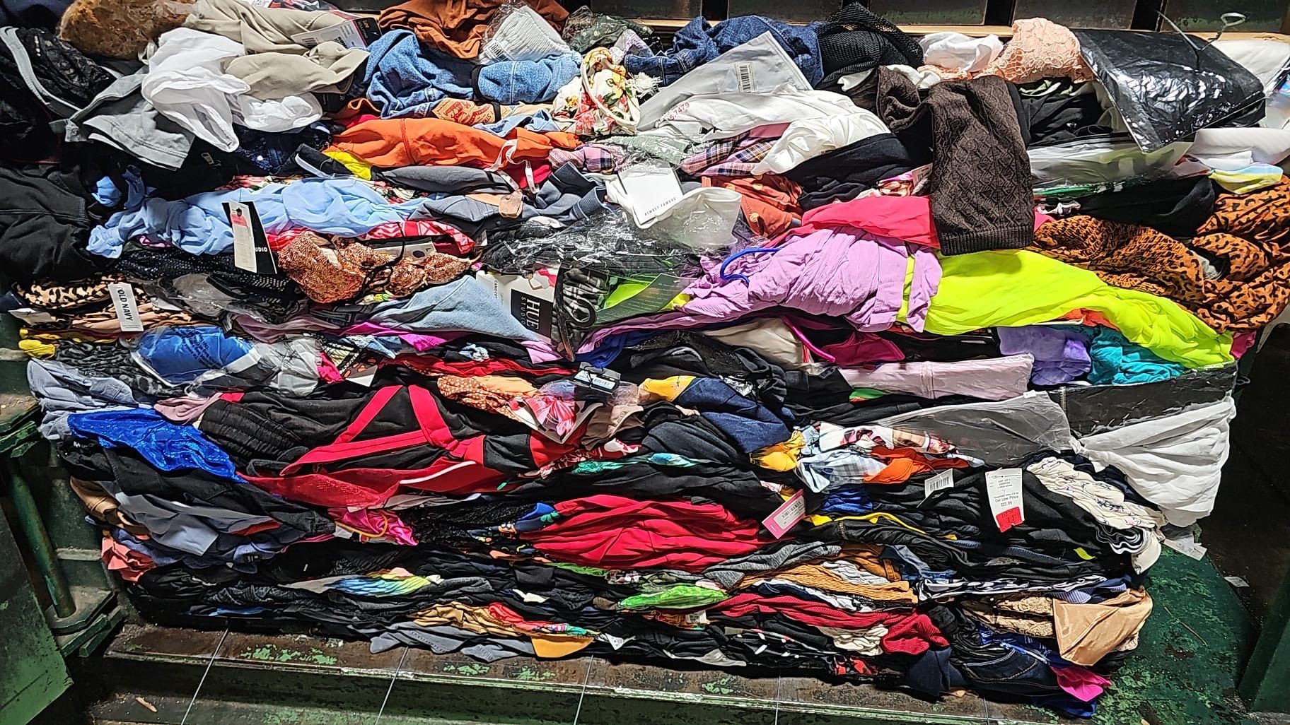 A pile of colorful clothes is sitting on top of a green table.