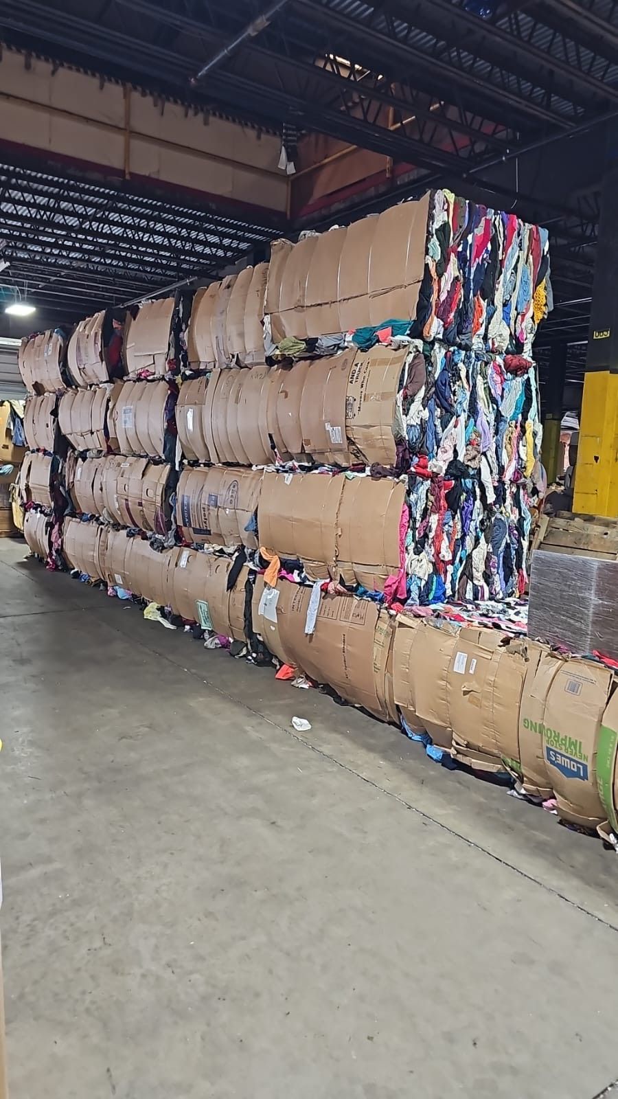 A warehouse filled with lots of cardboard bales stacked on top of each other.