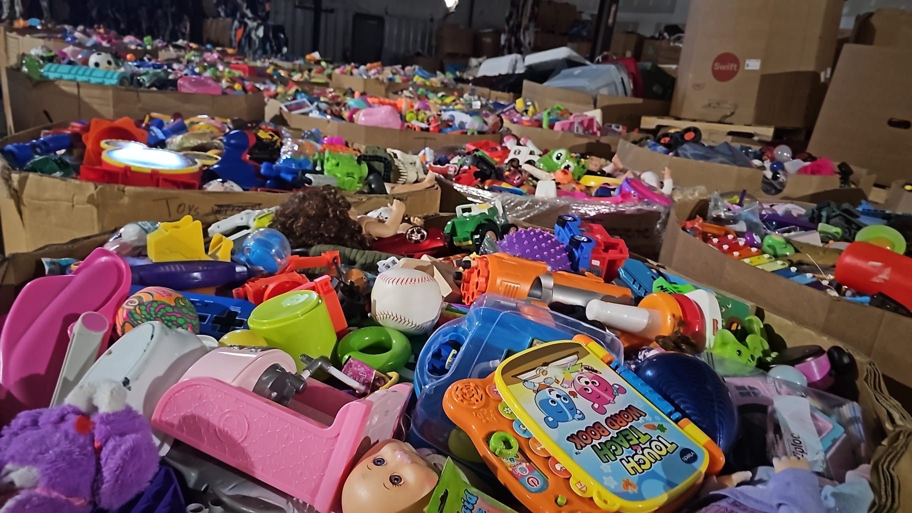 A bunch of toys are sitting on top of each other in boxes.