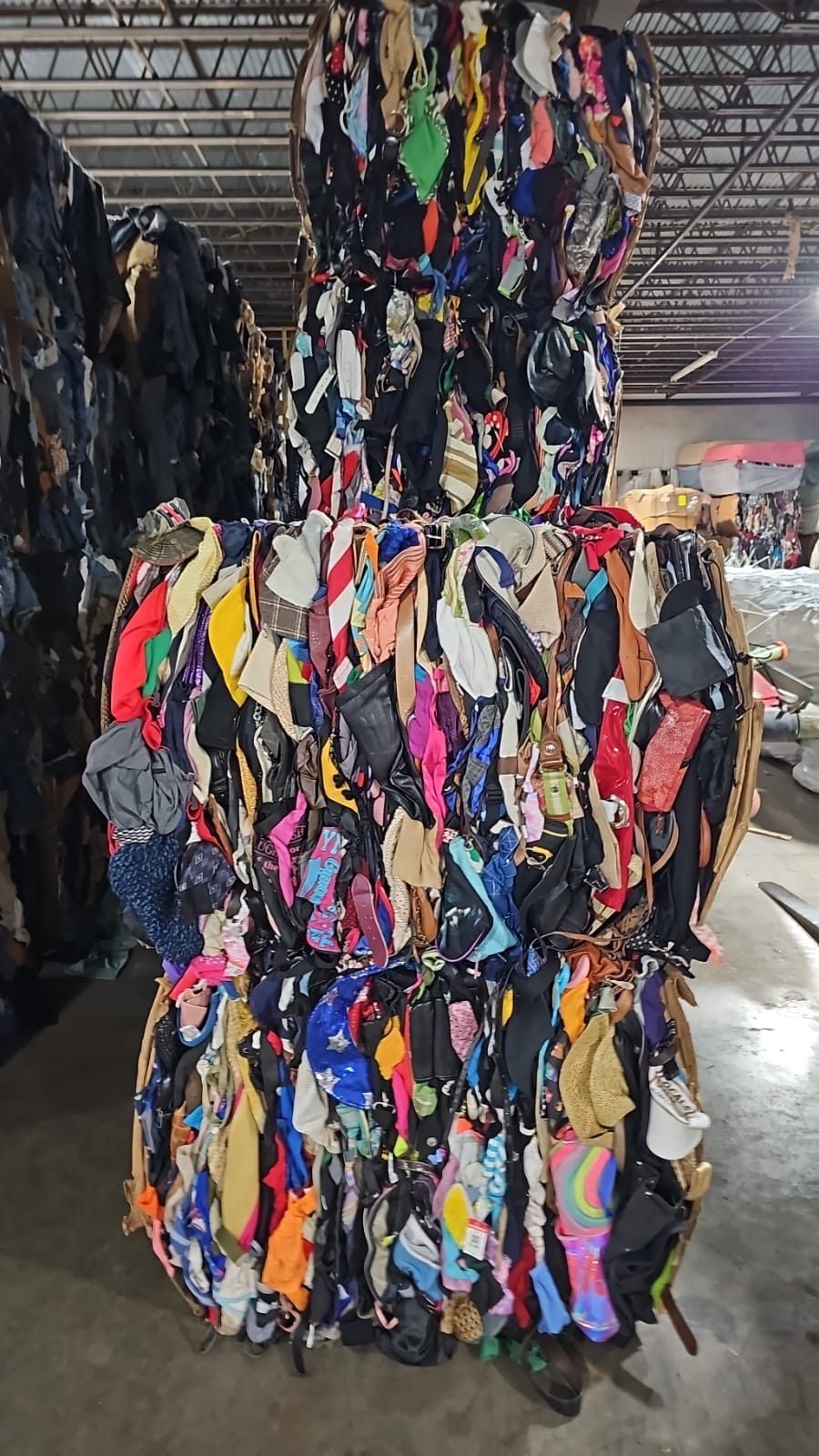 A pile of clothes is stacked on top of each other in a warehouse.