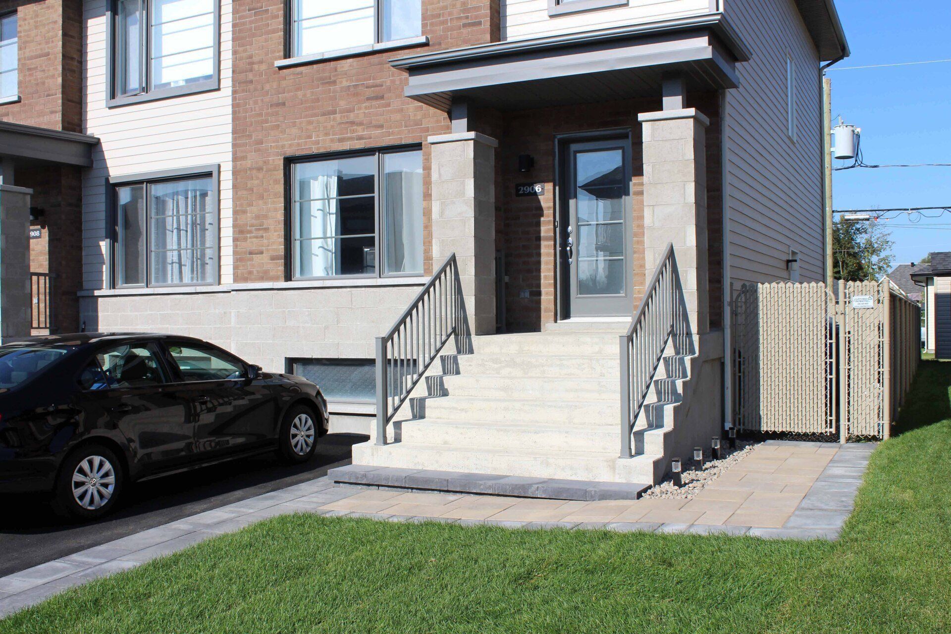 Une voiture est garée devant une maison avec des escaliers