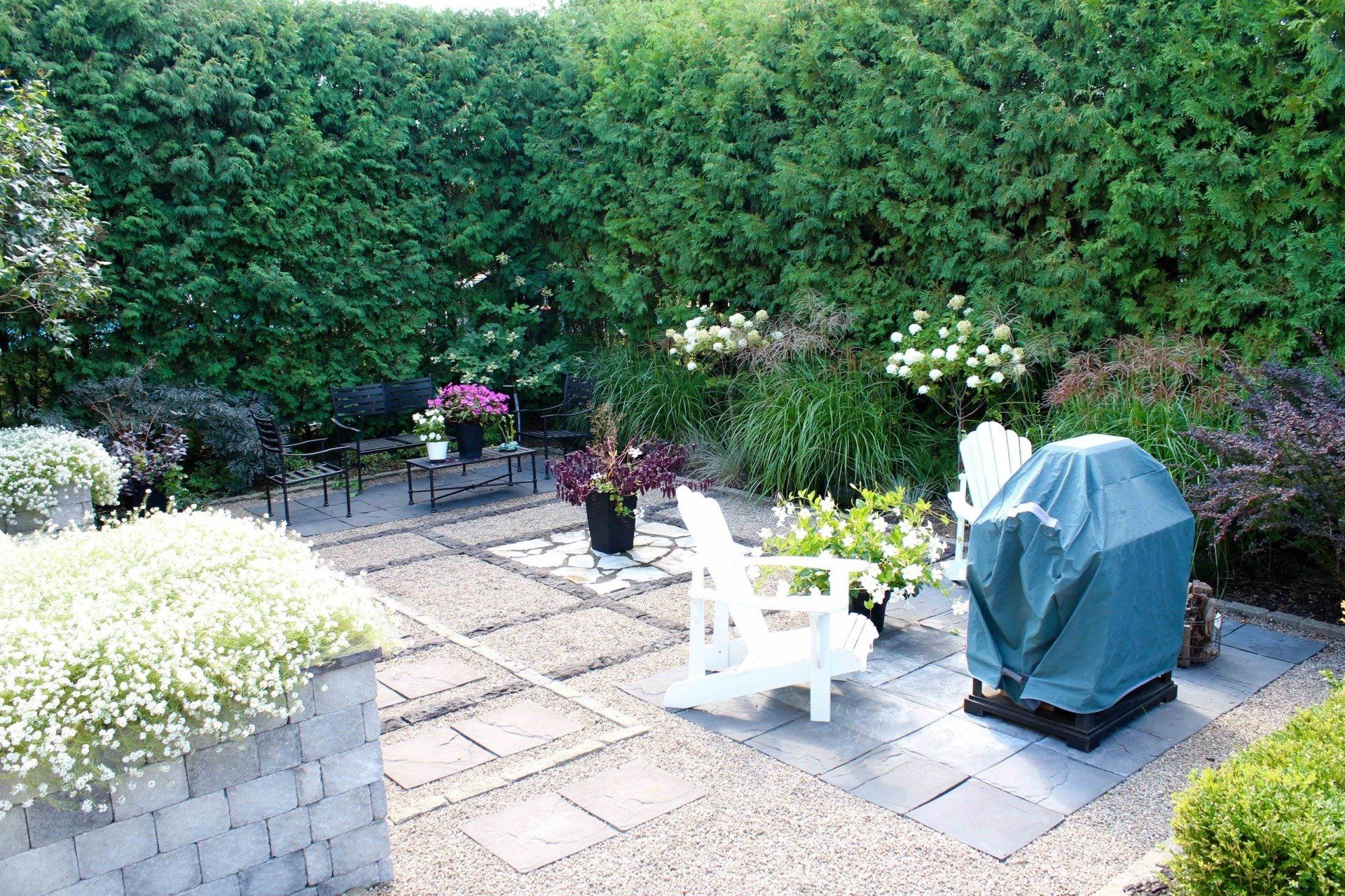 Un patio avec des chaises et un grill avec une couverture bleue