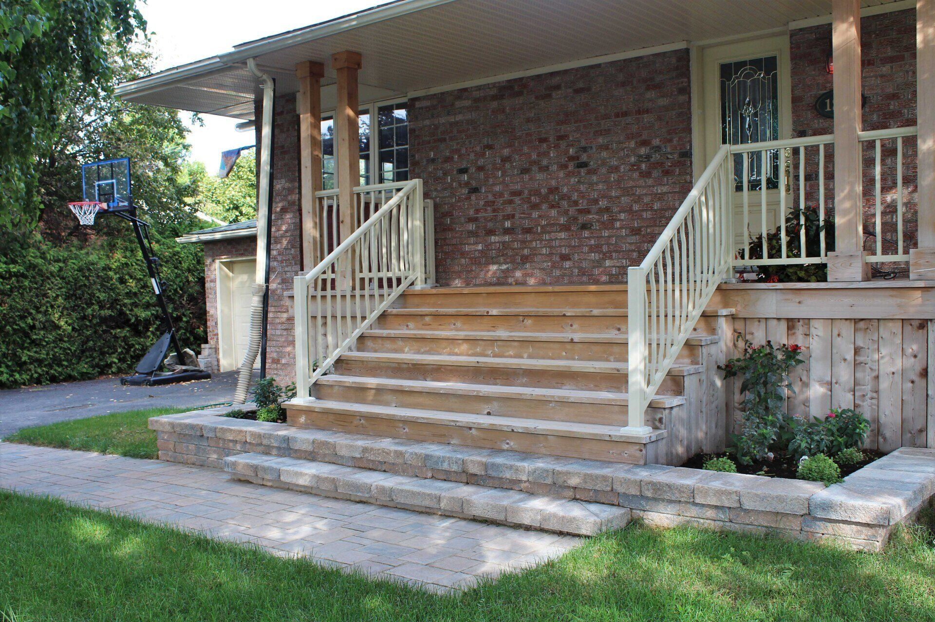 Une maison avec des escaliers et un panier de basket devant