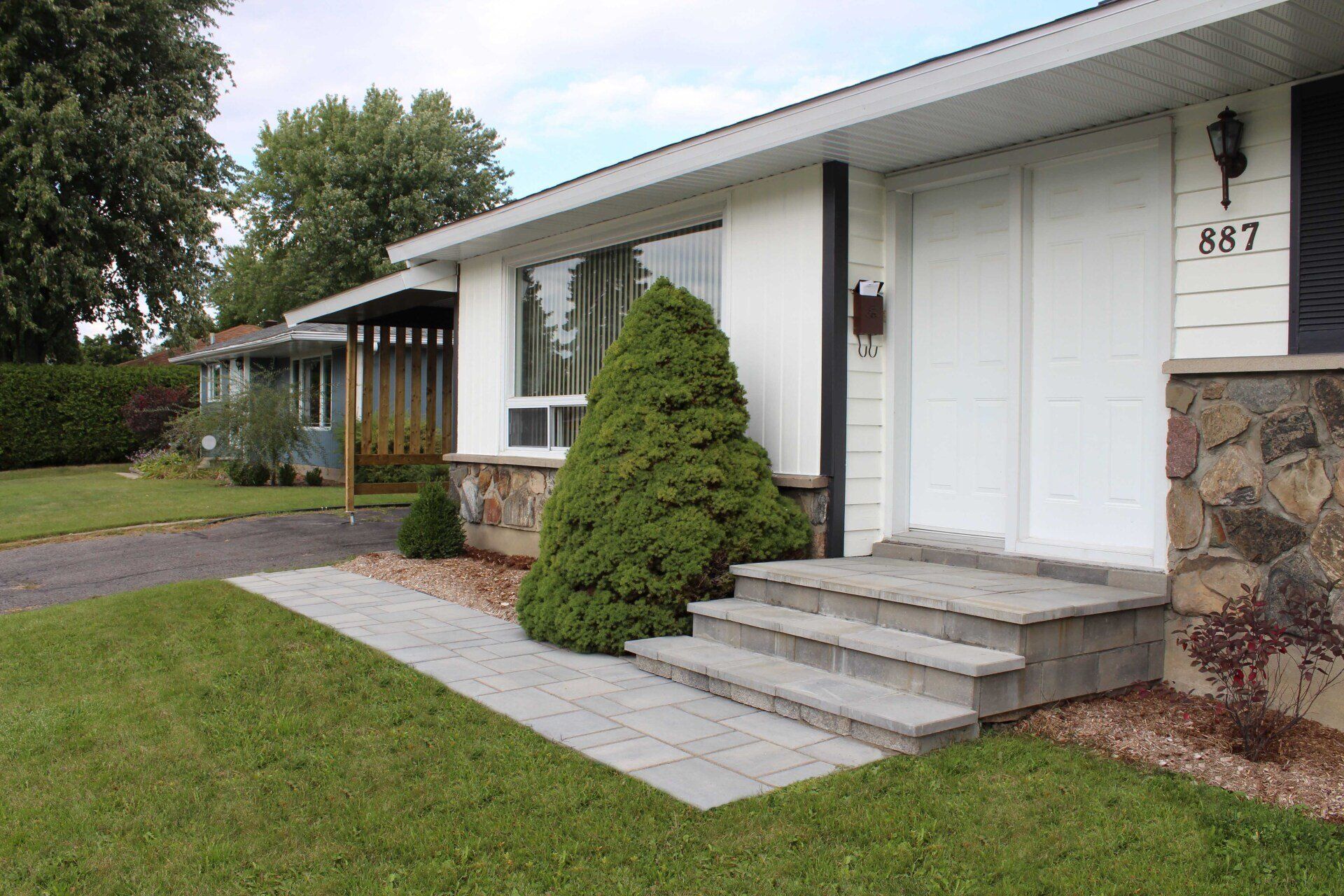 Une maison blanche avec le numéro 887 sur la porte d'entrée