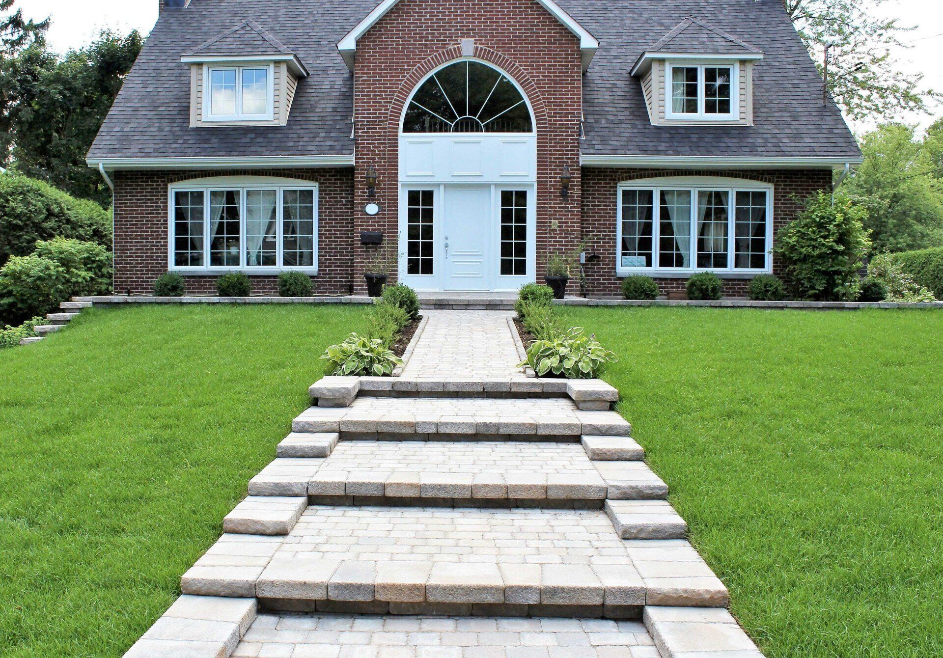 Une maison en brique avec des marches menant à la porte d'entrée