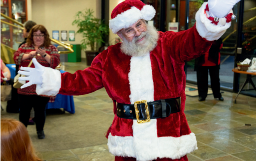 A man dressed as santa claus with his arms outstretched