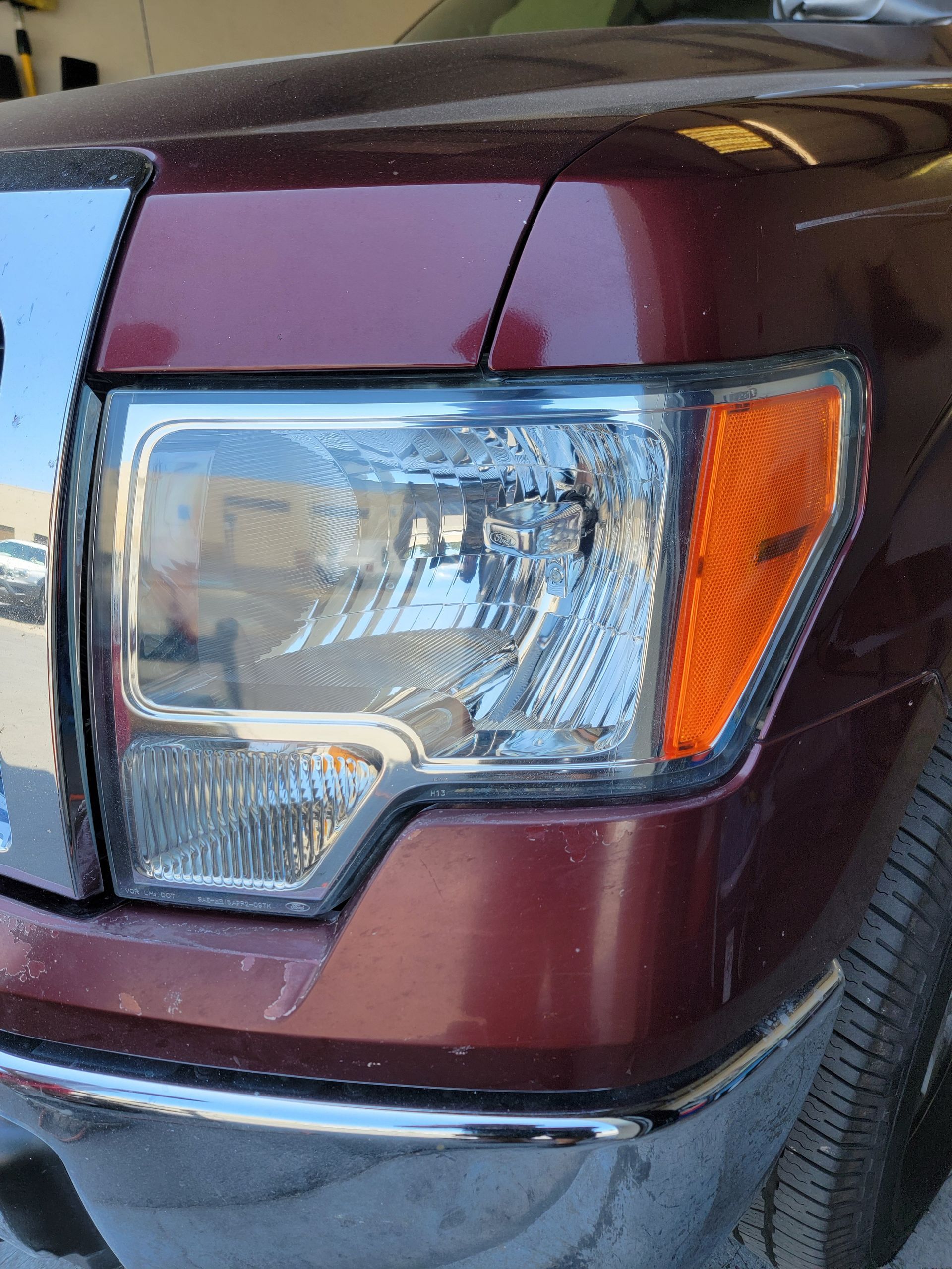 A close up of a red truck 's headlight.
