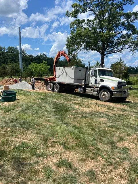 A large white truck is parked in a grassy field.