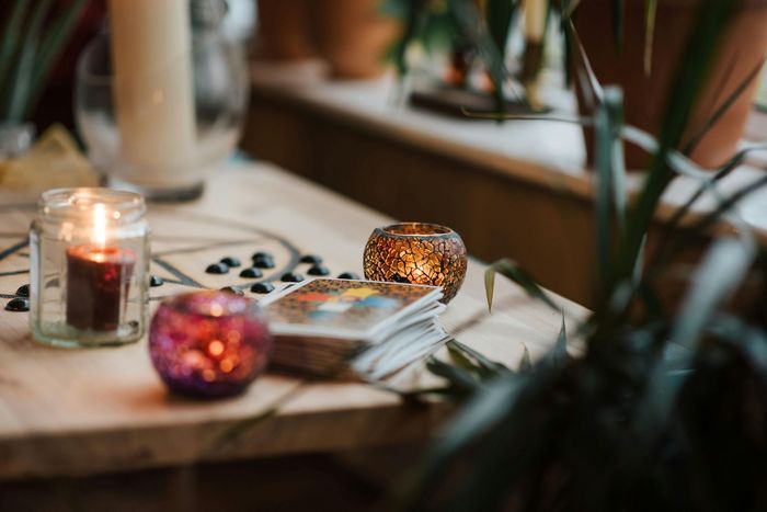 A table with candles and tarot cards on it.