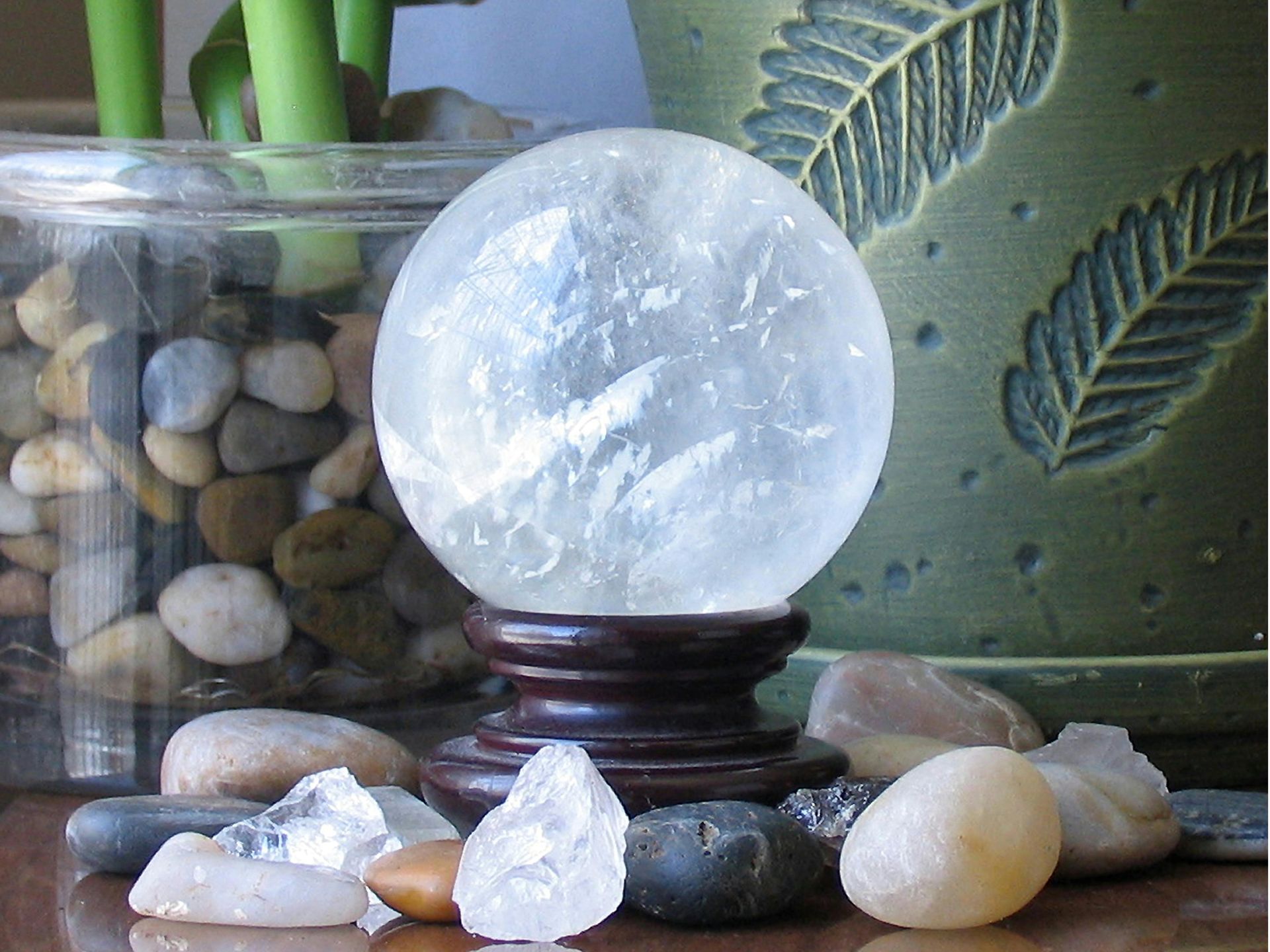 A crystal ball sits on a wooden stand surrounded by rocks