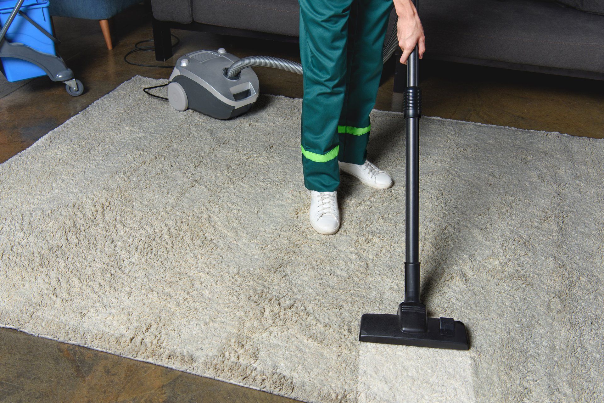 A person is vacuuming a rug in a living room.