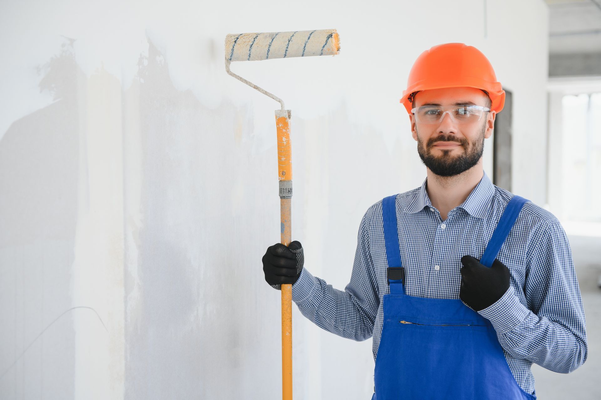 A man is holding a paint roller.