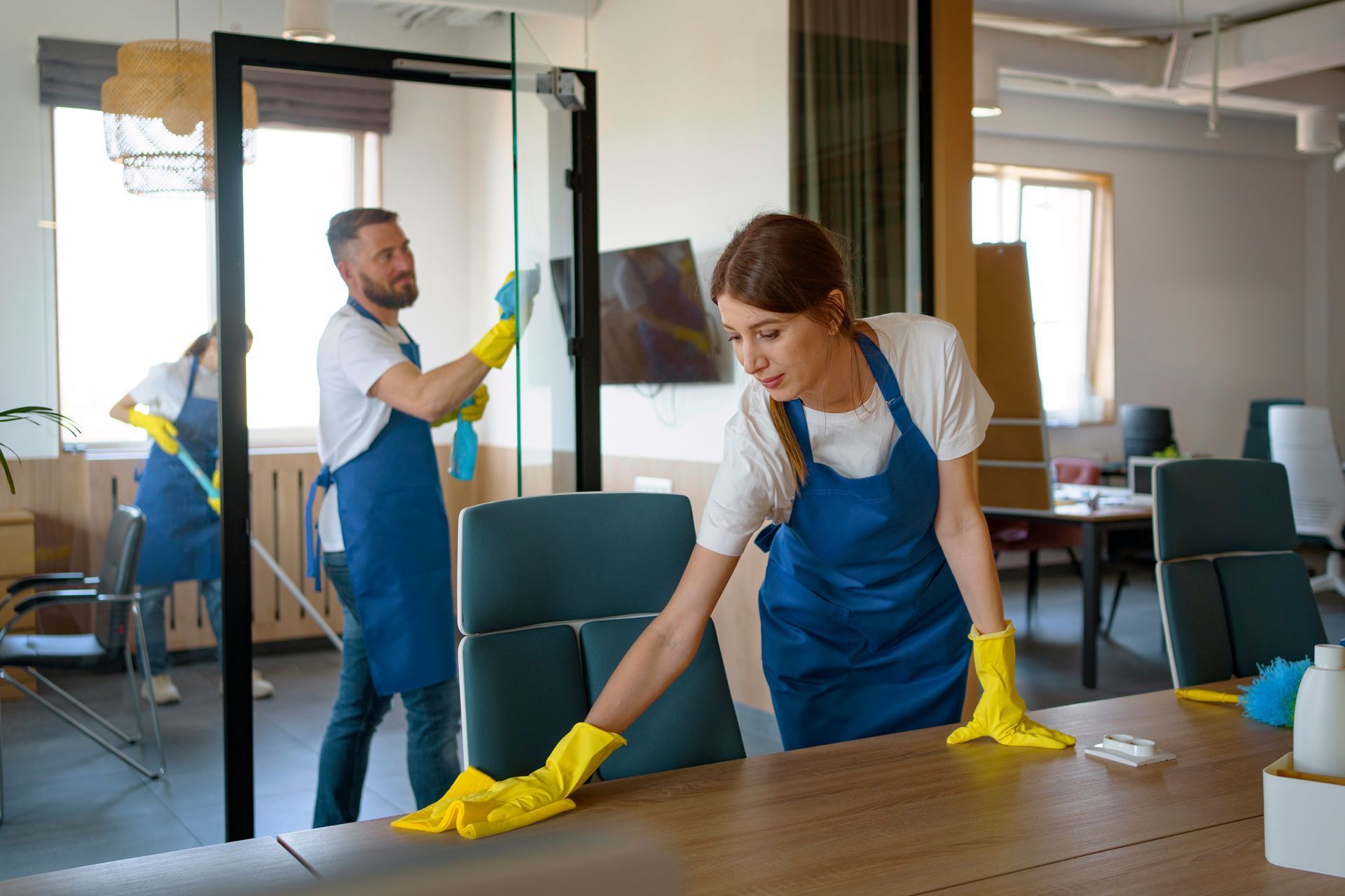 A man and a woman are cleaning an office.