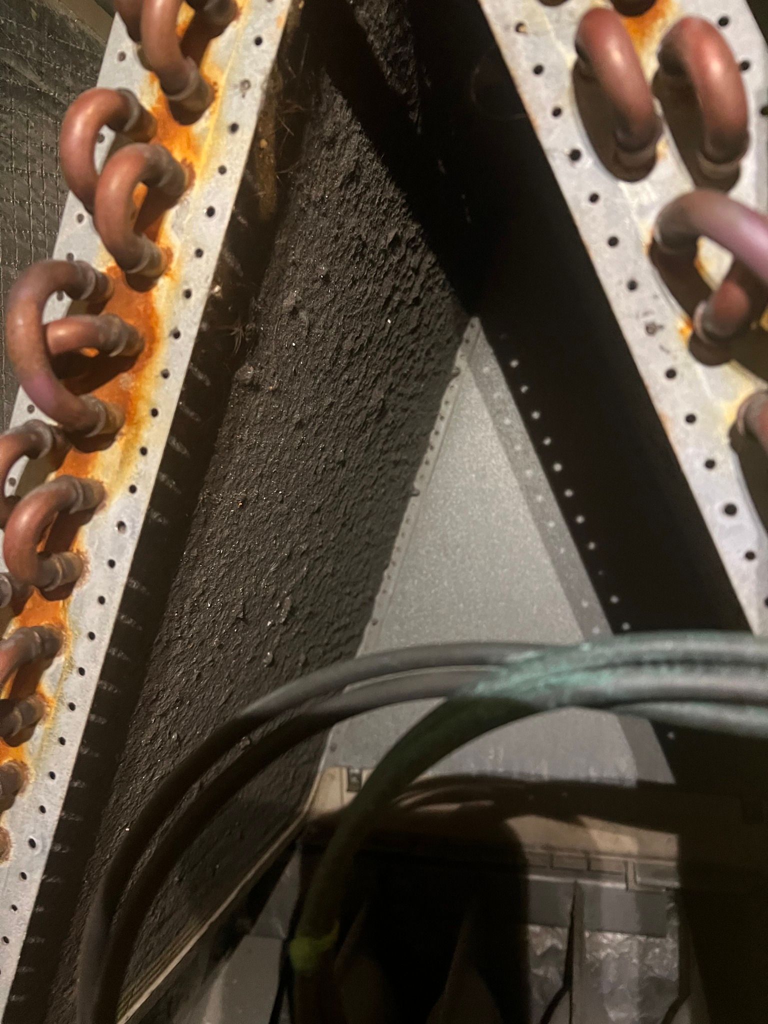 Comfy Castle Heating and Air - A close up of a rusty coil on a machine