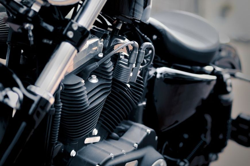 A close up of the engine of a black motorcycle.