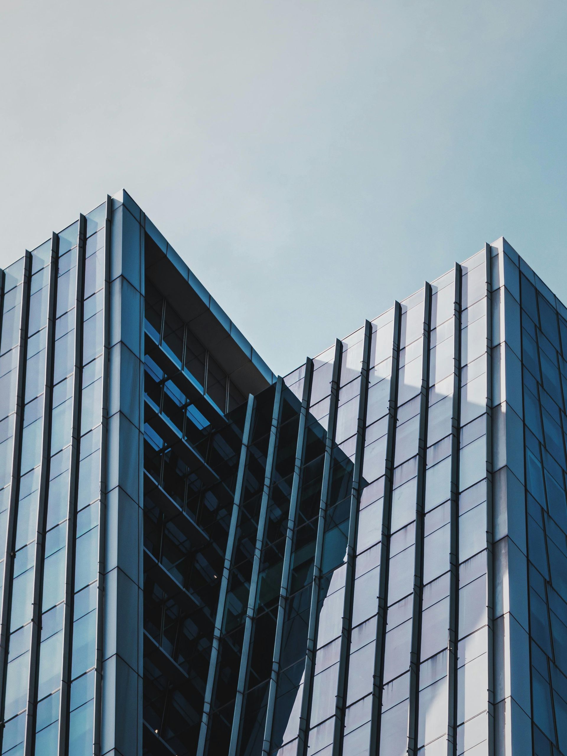 A hotel room with two beds , a couch , a table and a mirror.