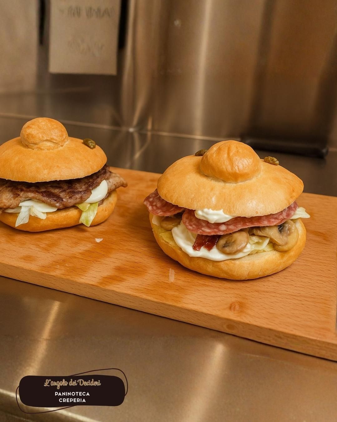 Due panini rotondi con condimenti su un tagliere di legno.