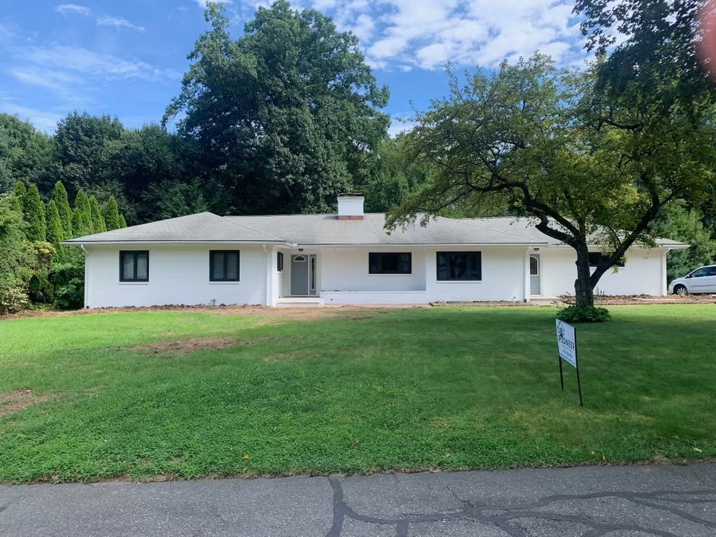 a white house with a large lawn in front of it-white exterior home painting in East Longmeadow, MA