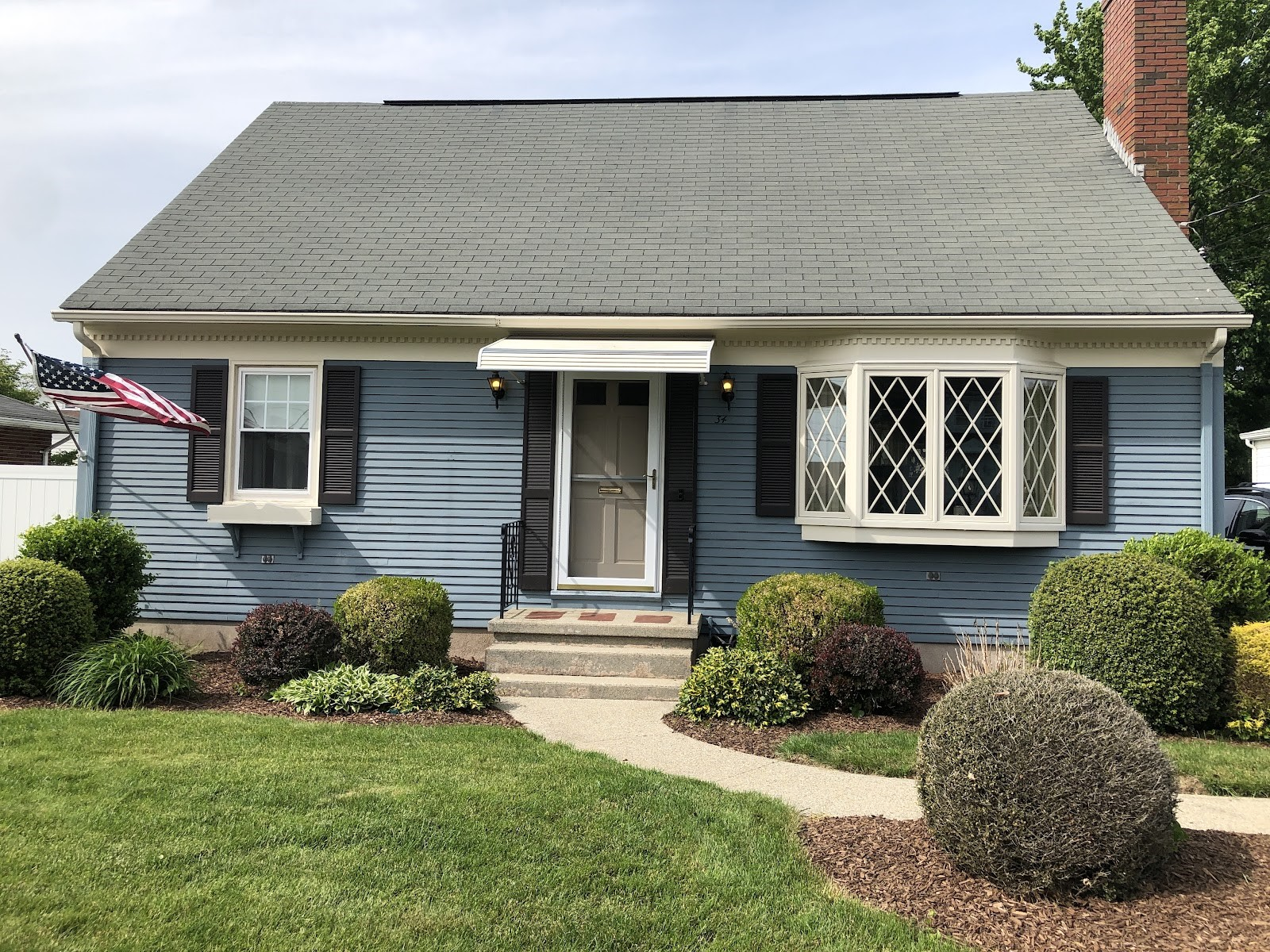 a blue house with a gray roof and black shutters