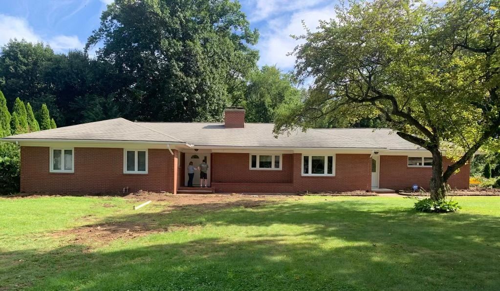 a large brick house with a large lawn in front of it .