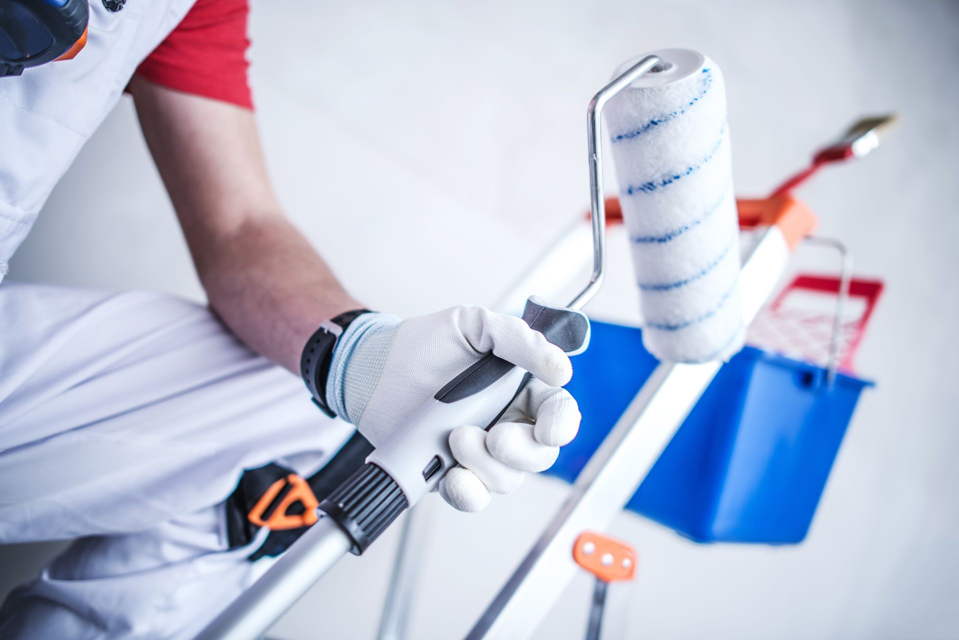 a man is holding a paint roller with a blue and white stripe on it