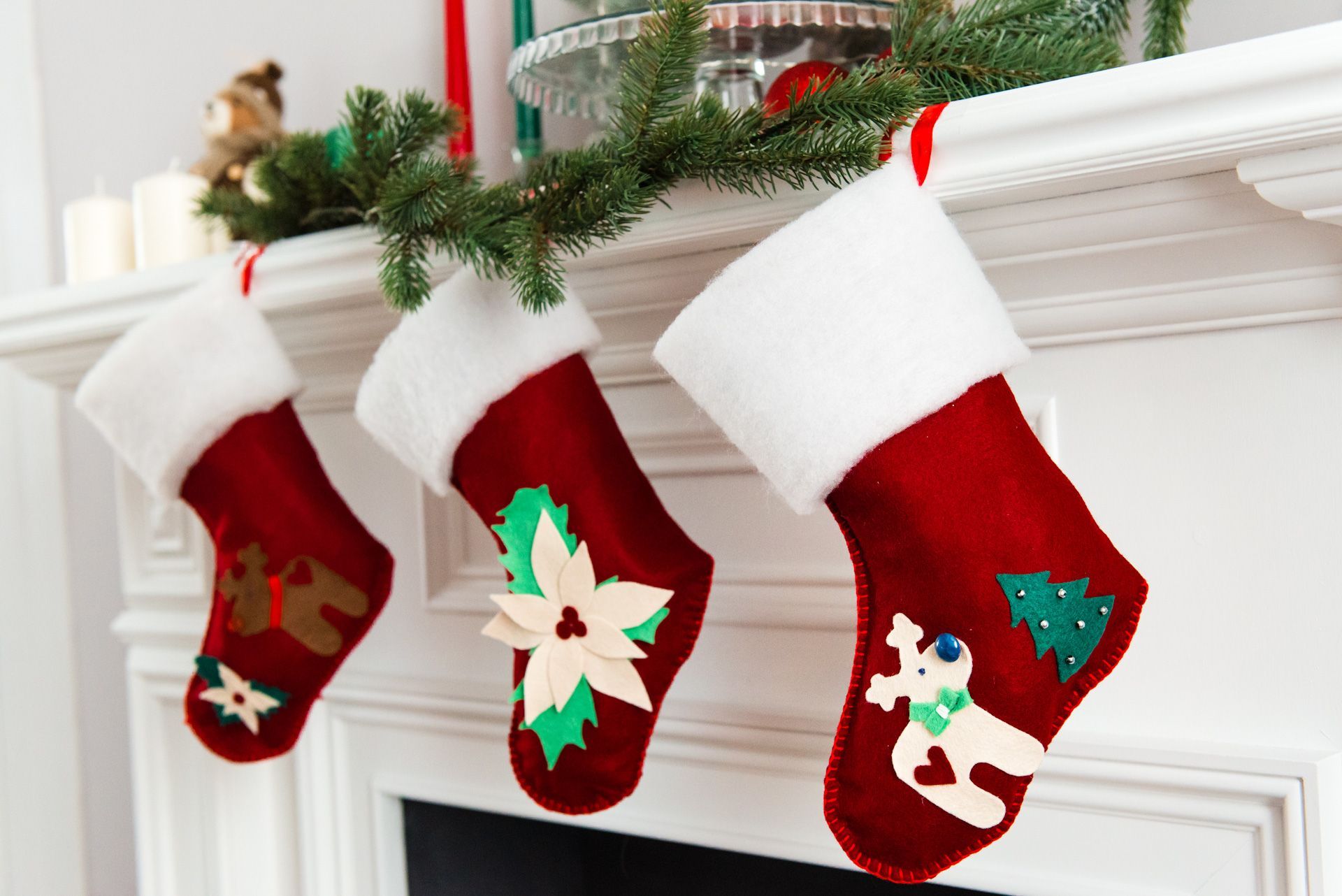Three Christmas stockings are hanging on a mantle