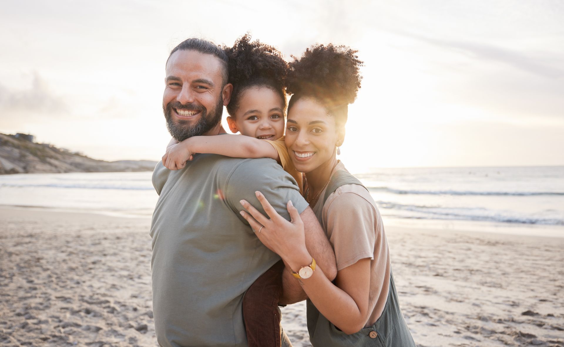 A family is posing for a picture on the beach.