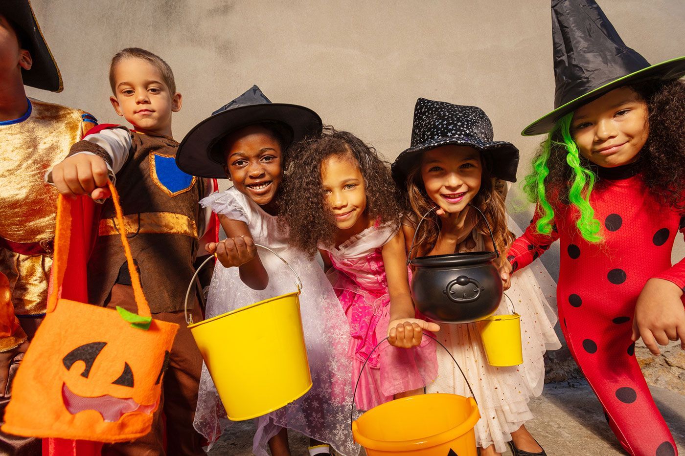 Halloween kids group together with candy buckets