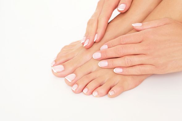 Primer plano de unas manos apoyadas sobre unos pies, ambos con uñas bien