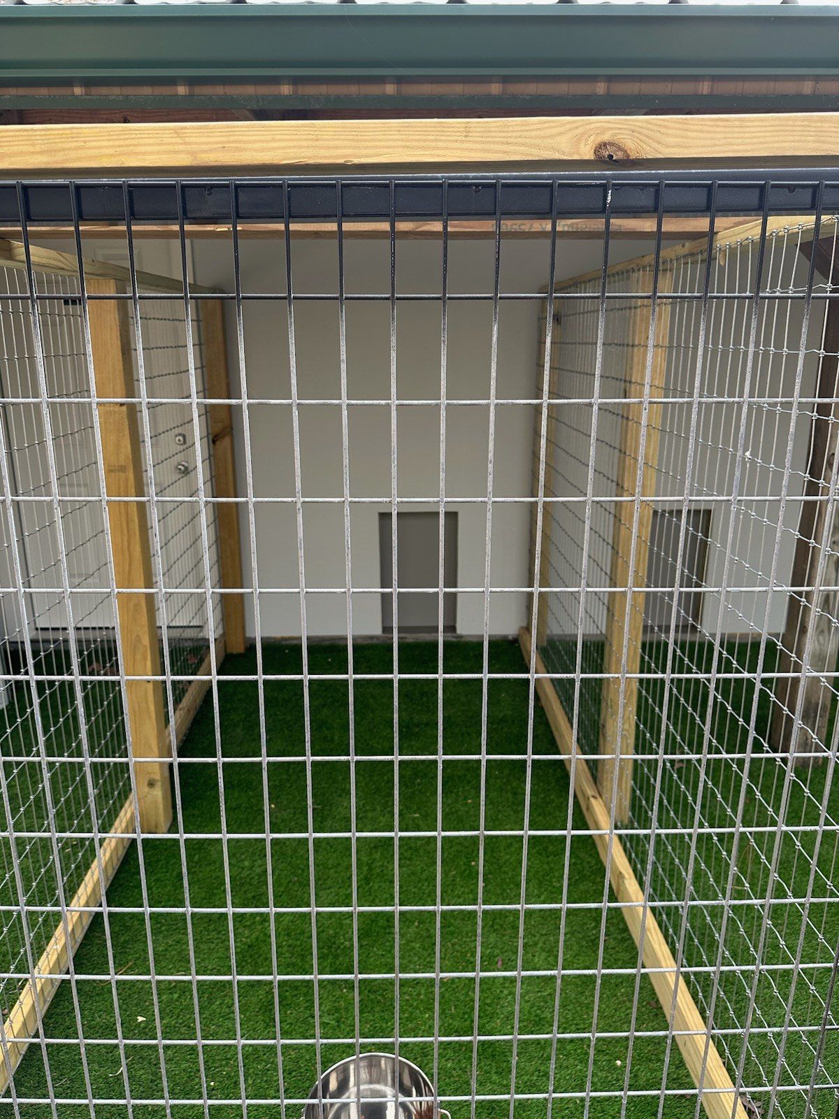 A dog is behind a wire fence in a cage.